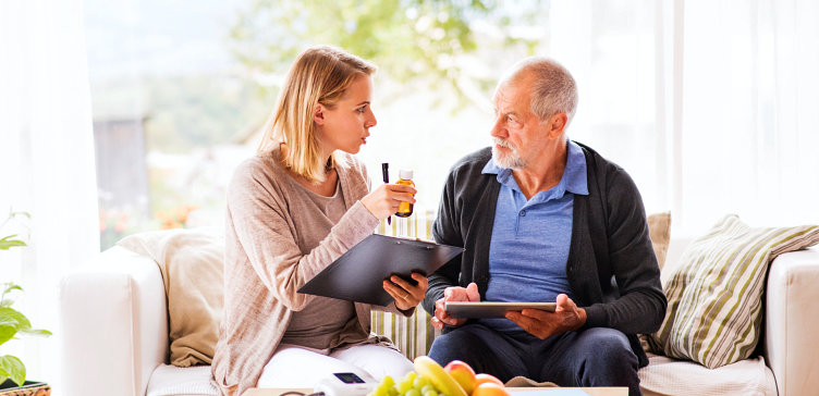 elder man with caregiver with medicine