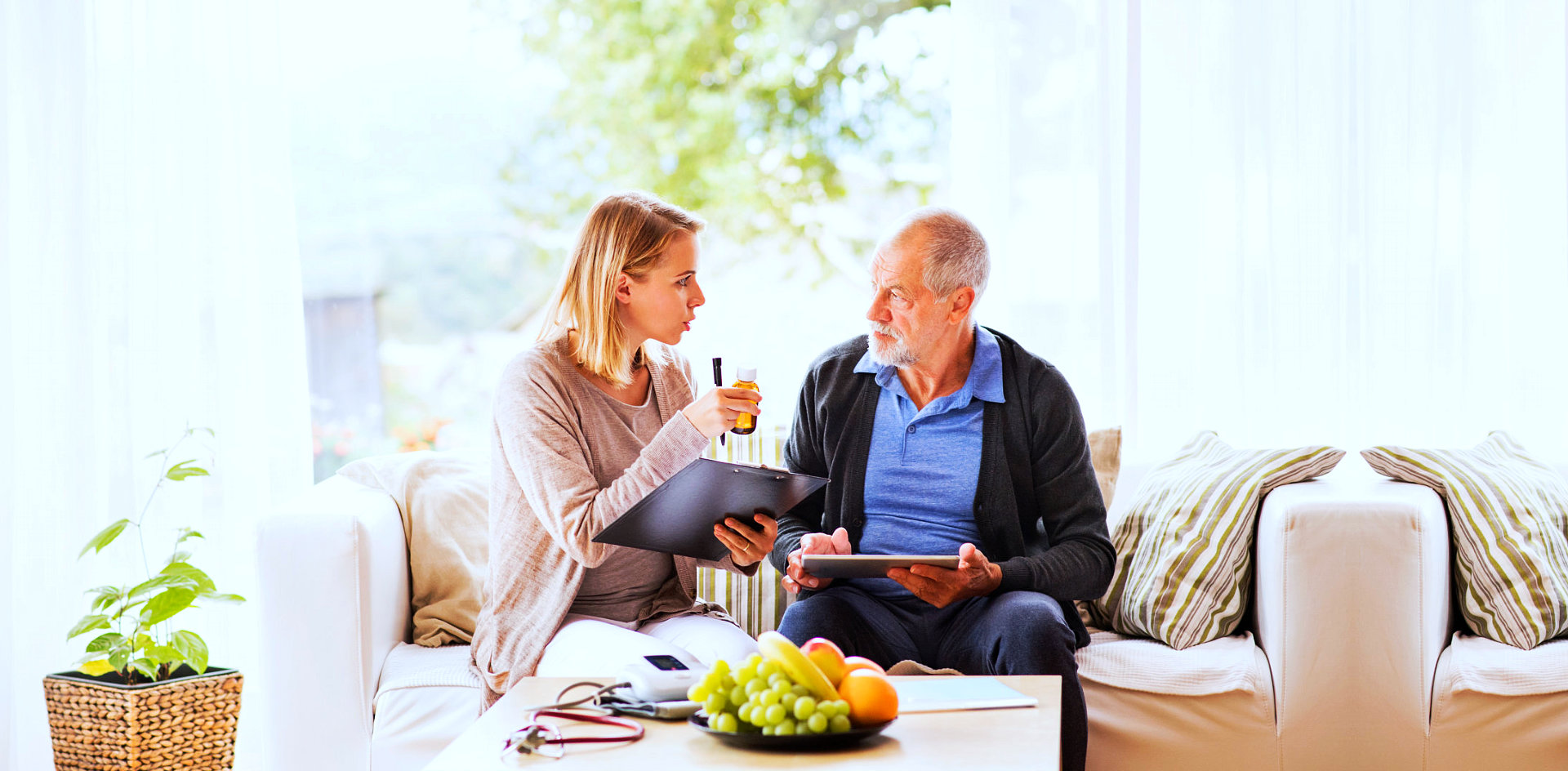 elder man with caregiver with medicine on her hands