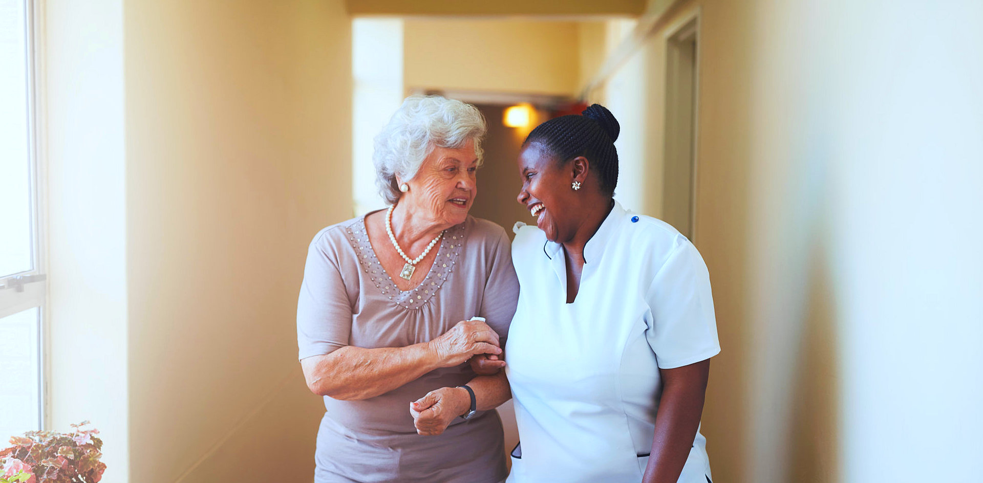 elder woman with caregiver smiling at each other