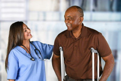 caregiver with elder man smiling