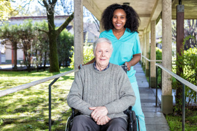 african nurse helping man on the wheelchair