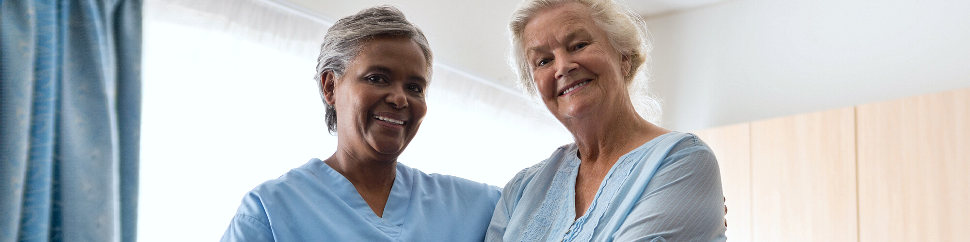 elder woman with caregiver smiling